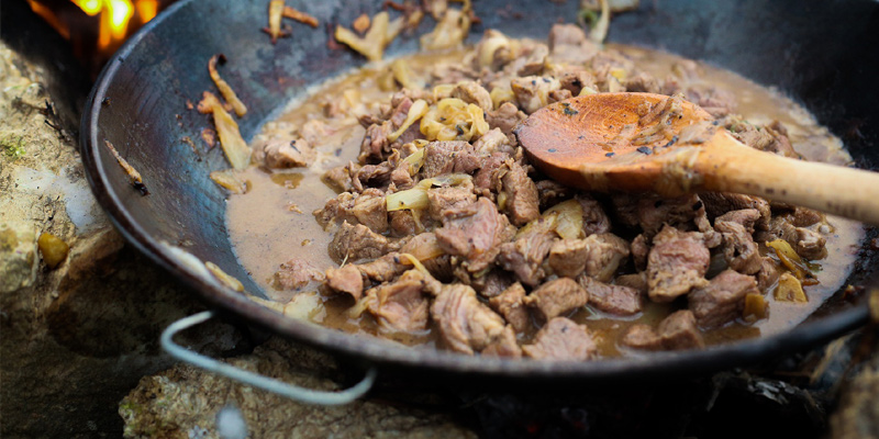 Mit dem Wok über offenem Feuer kochen