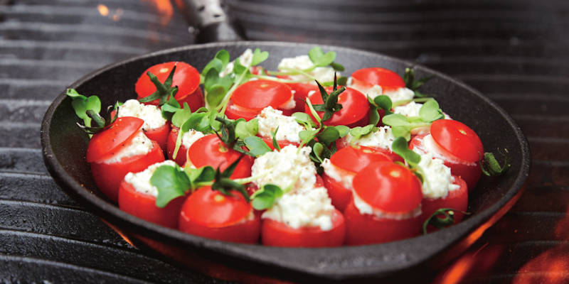 Grillpfanne mit gefüllten Tomaten auf dem Grill